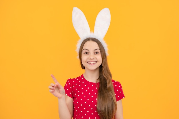 Retrato de niño adolescente con orejas de conejo aislado en fondo amarillo