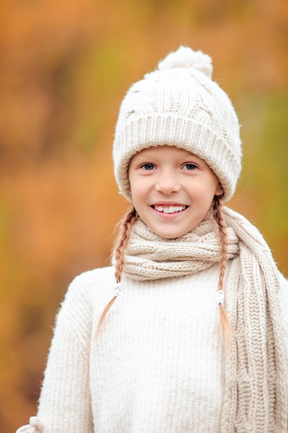 Retrato de niño adorable con hojas amarillas en otoño. Otoño