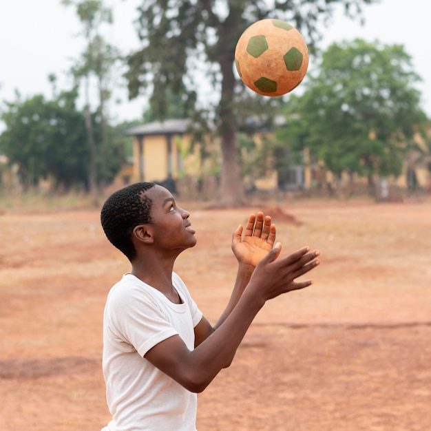 Foto retrato, niño africano, con, pelota del fútbol