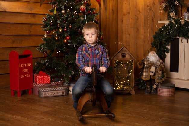 Retrato de un niño alegre cerca del árbol de Navidad