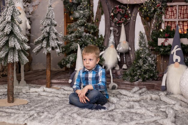 Retrato de un niño alegre cerca del árbol de Navidad