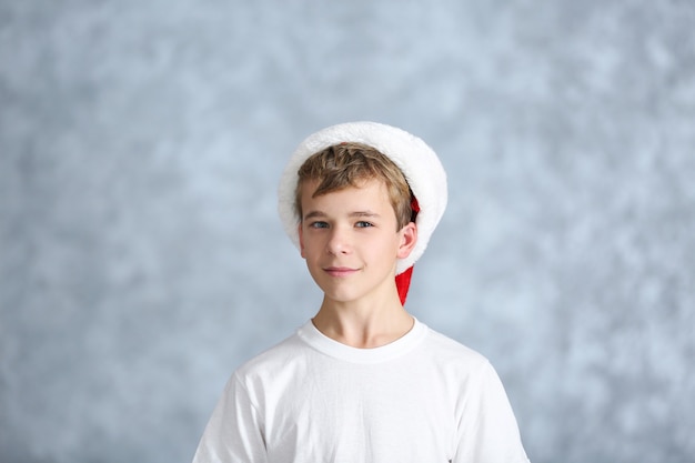 Retrato de niño alegre sobre superficie gris