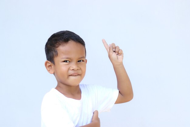 Retrato de niño asiático apuntando a algo. con espacio de copia para presentación de productos, publicidad y más