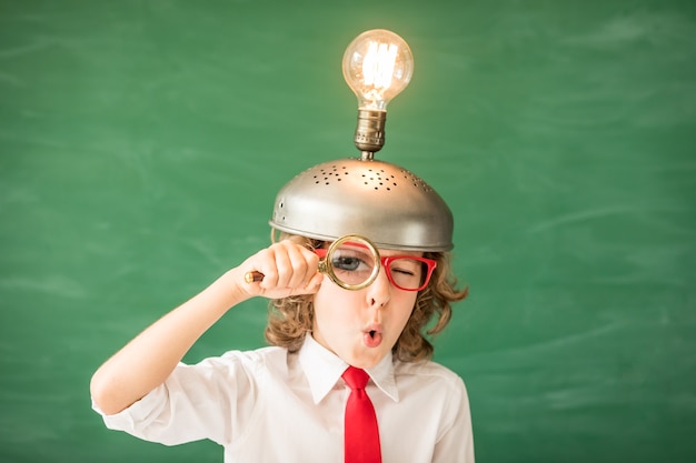 Retrato de niño en el aula. Niño con casco de realidad virtual de juguete en clase. Concepto de tecnología de éxito, idea e innovación. De vuelta a la escuela