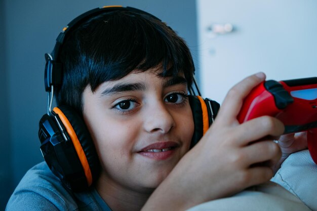 Foto retrato de un niño con auriculares sosteniendo un joystick