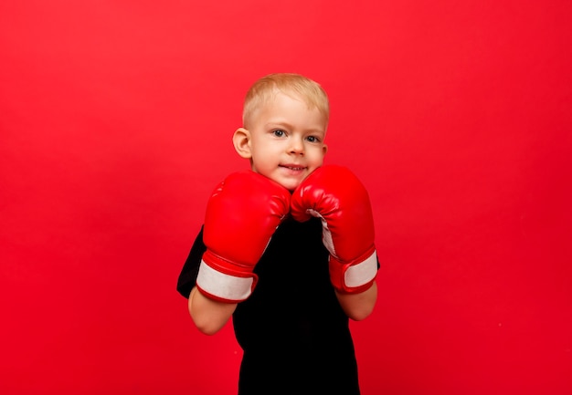 Retrato de un niño boxeador en guantes de boxeo en rojo