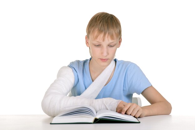 Retrato de niño con un brazo roto leyendo un libro