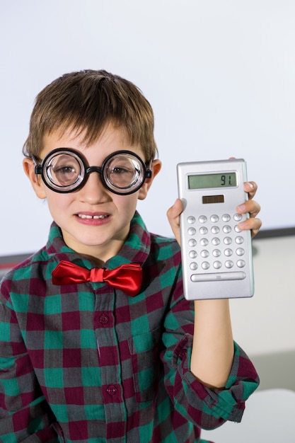 Retrato de niño con calculadora en el aula