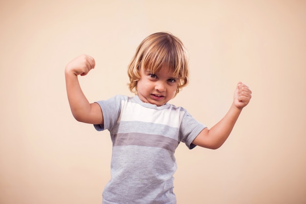 Retrato de niño chico mostrando manos fuertes. Niños y concepto de salud