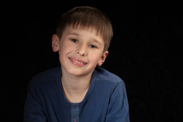 Retrato de un niño de diez años sobre un fondo oscuro