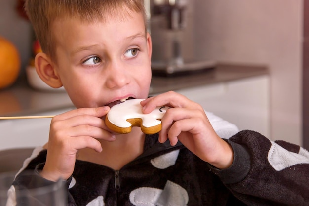 Retrato de niño disfrazado de esqueleto comiendo galletas caseras que parecen fantasmas