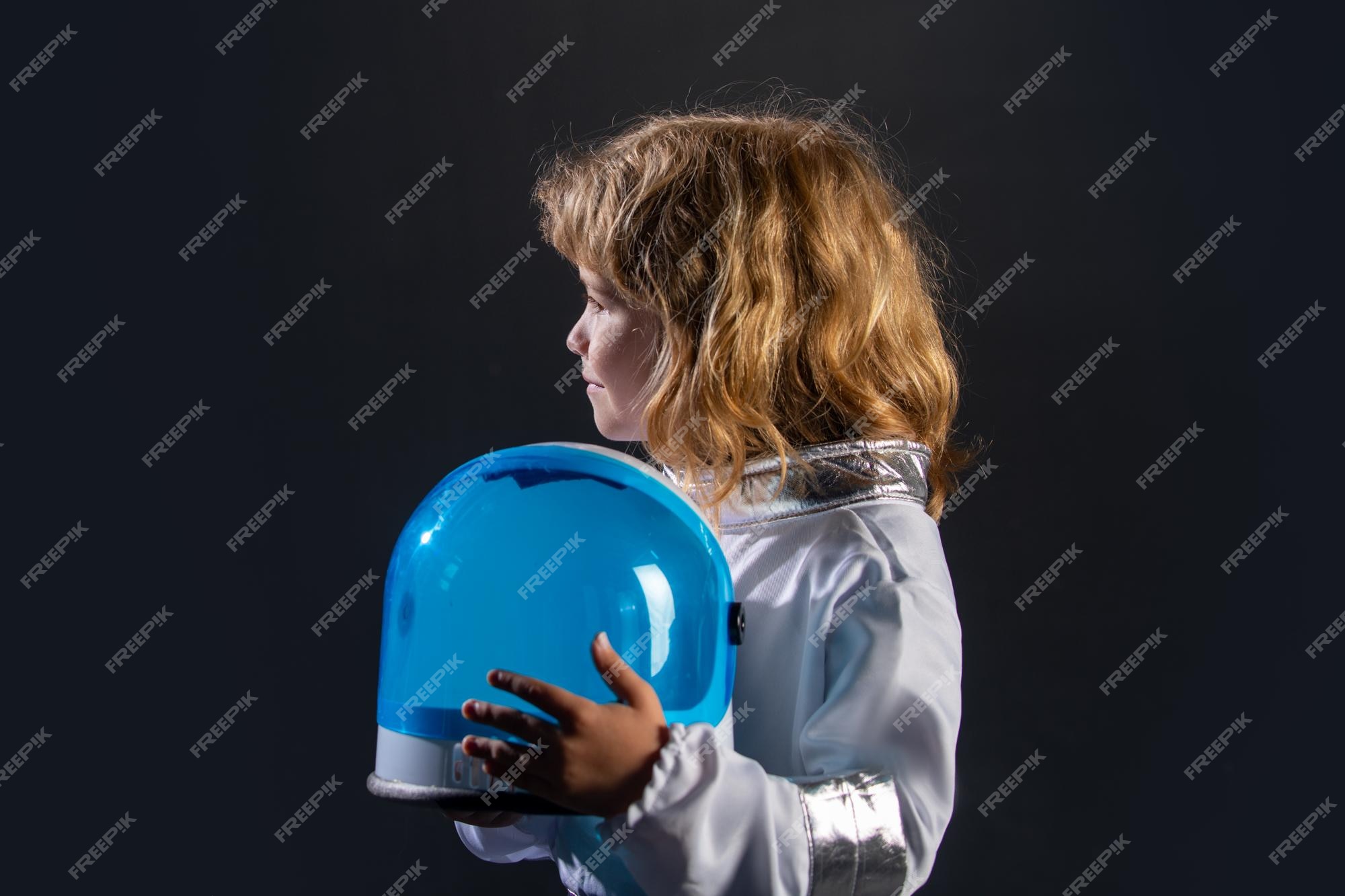 Retrato de niño divertido con casco de astronauta niño pequeño lindo  astronauta en traje espacial sosteniendo casco sobre fondo negro