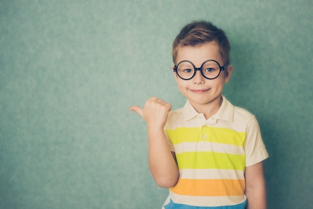 Retrato de niño con estilo con el dedo dedo en los puntos laterales.