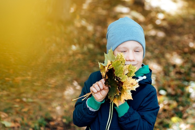 retrato de un niño feliz blanco con hojas de otoño, espacio para texto, temporada