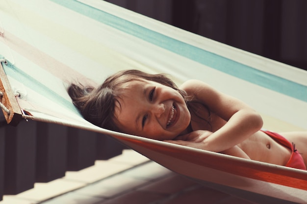 Foto retrato de un niño feliz sin camisa descansando en una hamaca