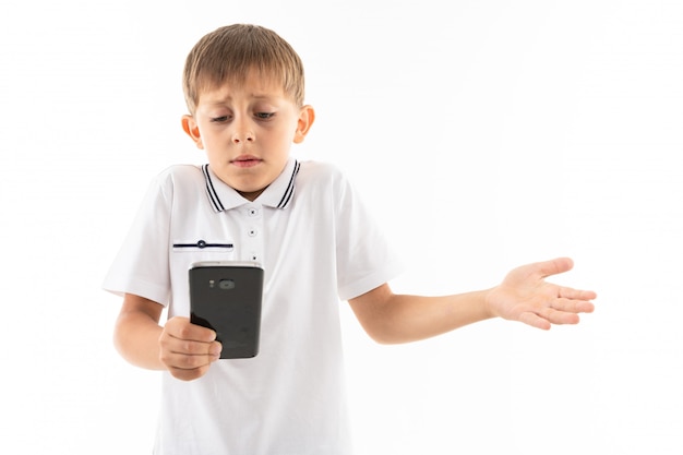 Retrato de niño feliz chateando con sus amigos o jugando juegos telefónicos e infelices