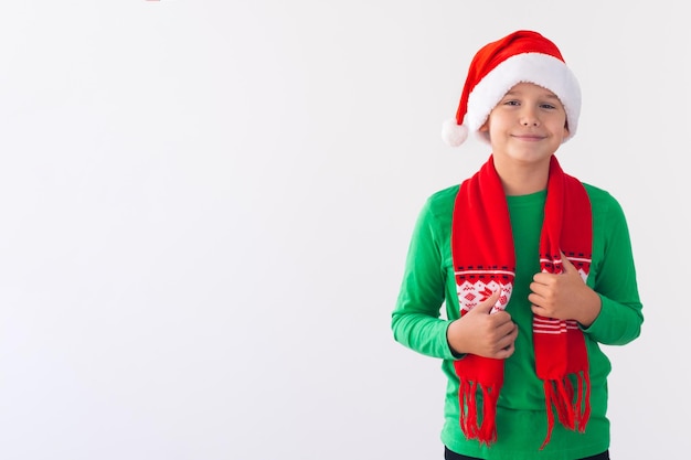 Retrato de niño feliz con sombrero de Santa Claus y bufanda de invierno Feliz Navidad