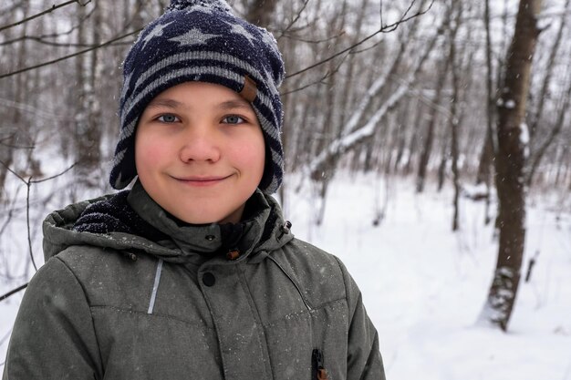 Retrato de un niño en el fondo de un bosque de invierno