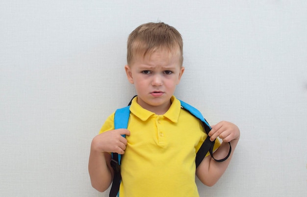 Un retrato de un niño frustrado, una cara triste de un niño, un niño infeliz mirando hacia afuera, un retrato emocional de un bebé, el concepto de niños mimados.