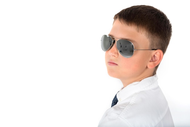 Retrato de un niño con gafas sobre un fondo blanco en el estudio.