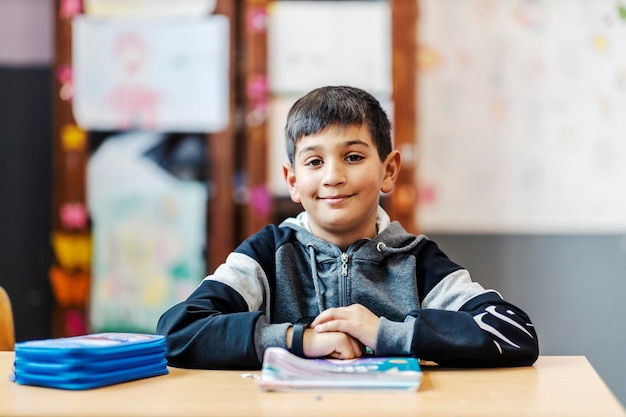 Retrato de un niño gitano inteligente después de una conferencia y sonriendo a la cámara