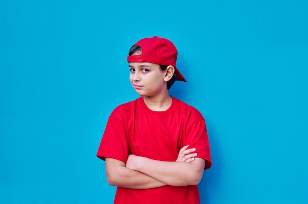 Un retrato de niño con gorra roja y camiseta con rostro desafiante