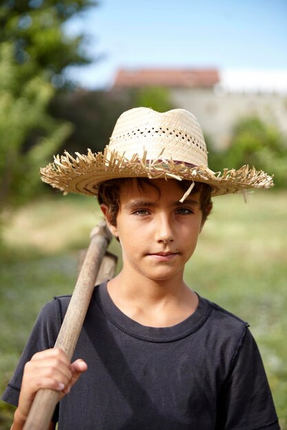 Foto retrato de un niño granjero en un campo bonita infancia