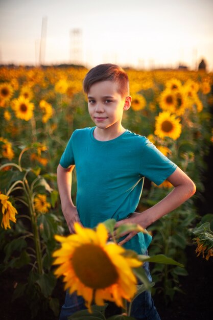 Retrato de niño hermoso niño rubio en campo de girasol de verano