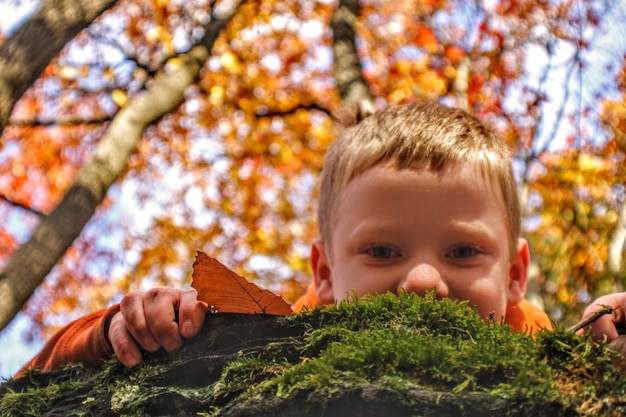 Foto retrato de un niño con hojas de otoño