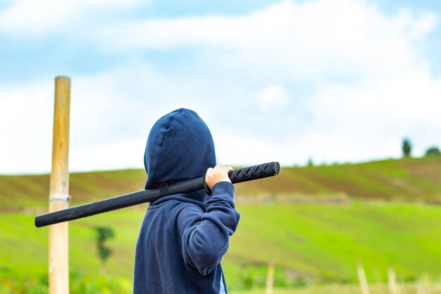 Retrato de un niño con un juego de espada de madera