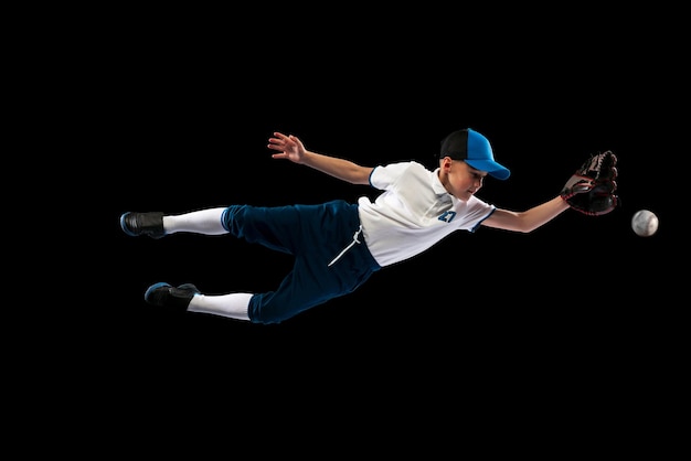 Foto retrato de niño jugador de béisbol en entrenamiento uniforme practicando aislado sobre fondo negro studio