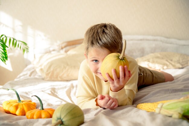 Foto retrato de un niño jugando con calabazas