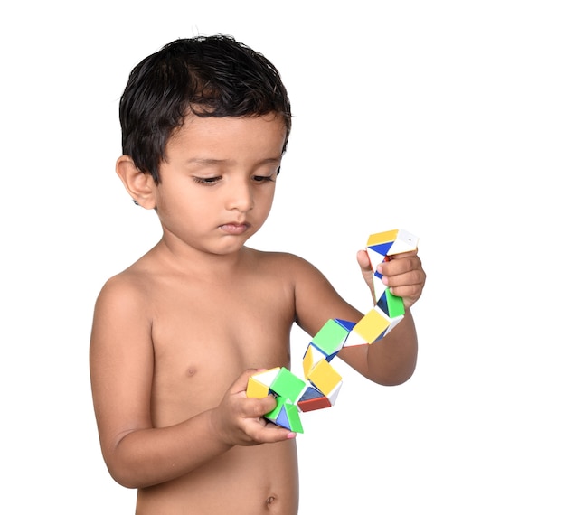 Retrato de niño jugando con juguetes sobre un fondo blanco.