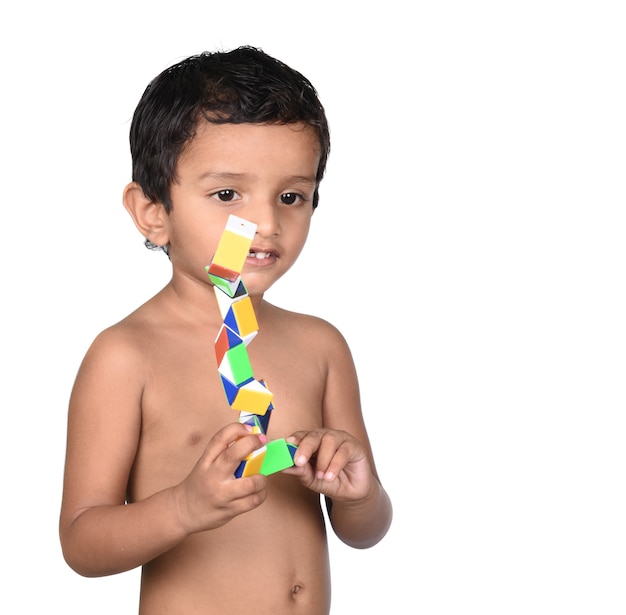 Retrato de niño jugando con juguetes sobre un fondo blanco.