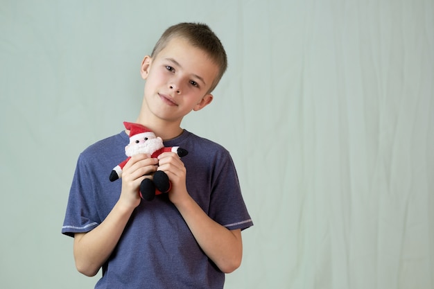 Retrato de un niño jugando con un pequeño juguete de Santa