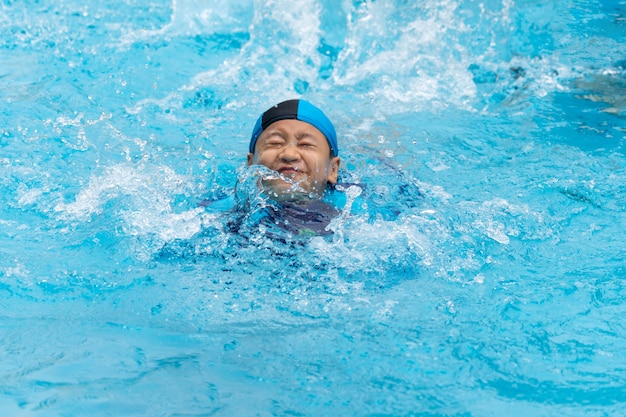 Retrato de un niño jugando en la piscina pública