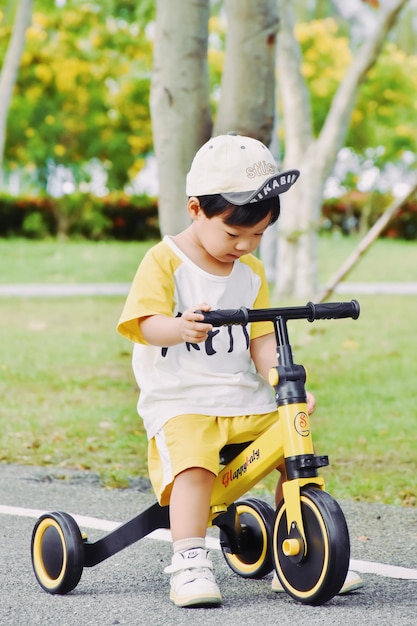 Foto retrato de un niño jugando con un scooter de empuje en el campo