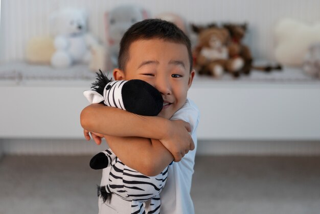 Foto retrato de niño jugando con su juguete de peluche