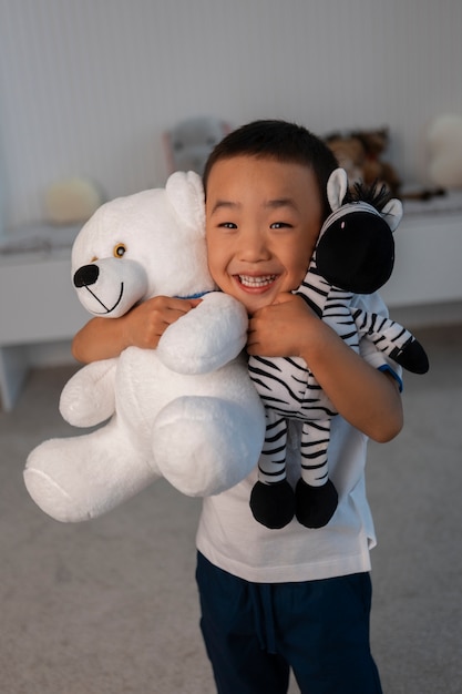 Retrato de niño jugando con su juguete de peluche