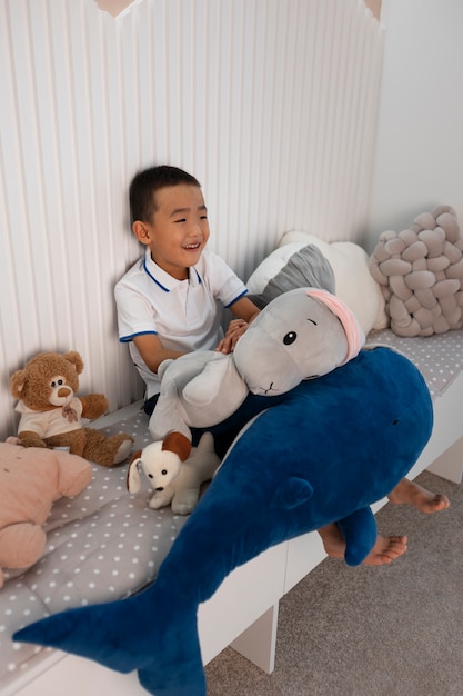 Foto retrato de niño jugando con su juguete de peluche