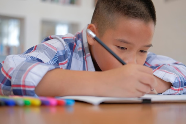 Foto retrato de un niño con un libro en la mesa