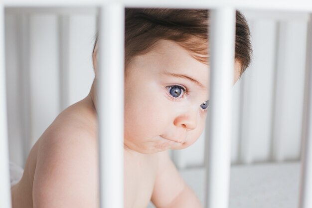 Retrato de niño lindo bebé en una cama blanca