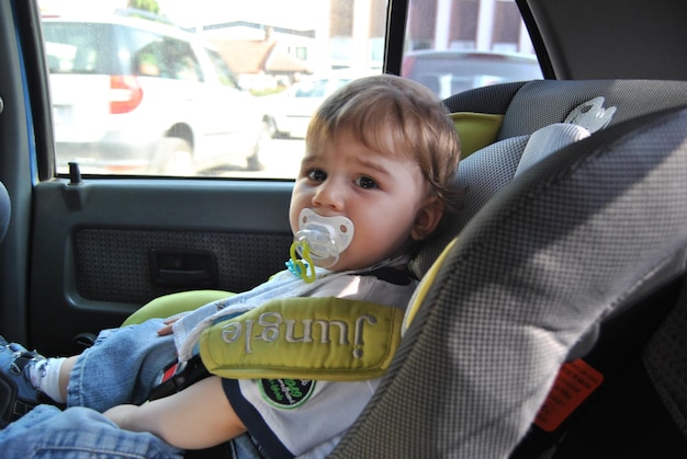 Foto retrato de un niño lindo en un coche