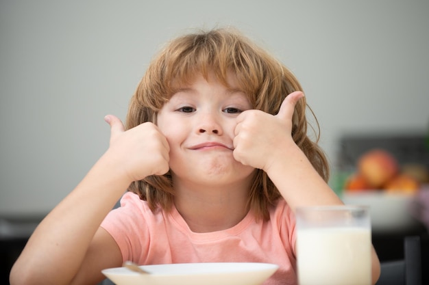 Retrato de un niño lindo comiendo sopa o desayunando almorzando junto a la mesa en casa con una cuchara Nutrición infantil Comida saludable para niños