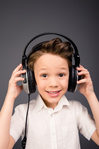 Foto retrato de niño lindo escuchando música en auriculares