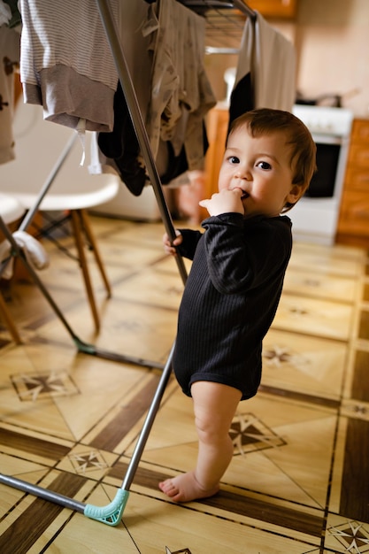 Retrato de niño lindo en el interior de la casa secando la ropa ayuda con las tareas del hogar