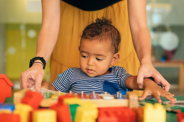 Foto retrato de un niño lindo con un juguete en la mesa