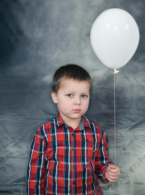 Retrato de un niño lindo mirando globos