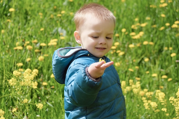 Retrato de niño lindo niño en pradera floreciente de primavera