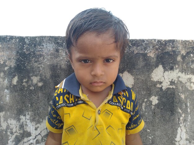 Foto retrato de un niño lindo de pie al aire libre